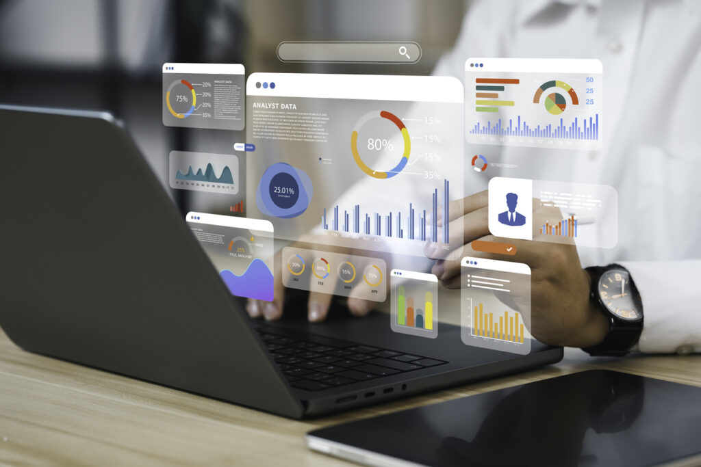 graphs and charts imposed over hands working at laptop keyboard