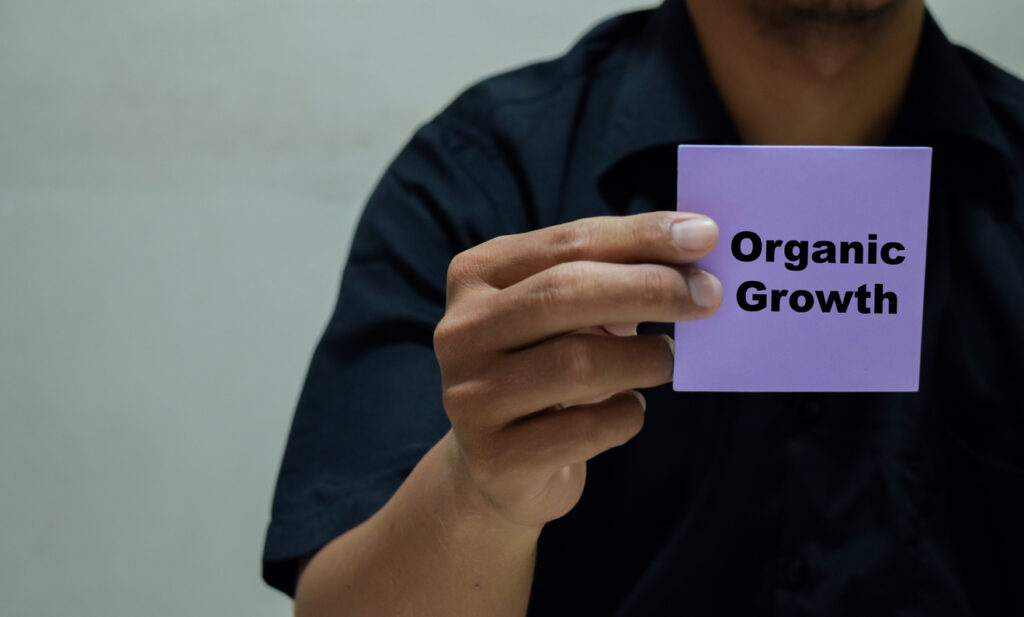 person holding note with organic growth written
